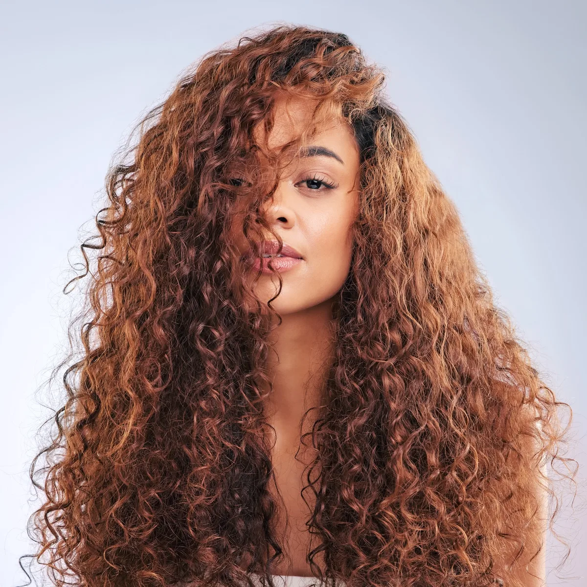 Curly-haired brunette in a guided AI hair analysis scan frame